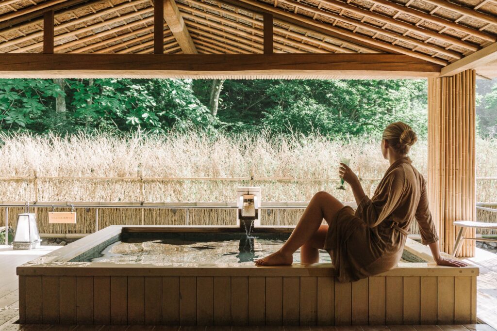 Tamu bersantai menikmati private onsen berdesain kayu dengan pemandangan alam yang tenang, fasilitas eksklusif Private Trip Jepang di Kinosaki