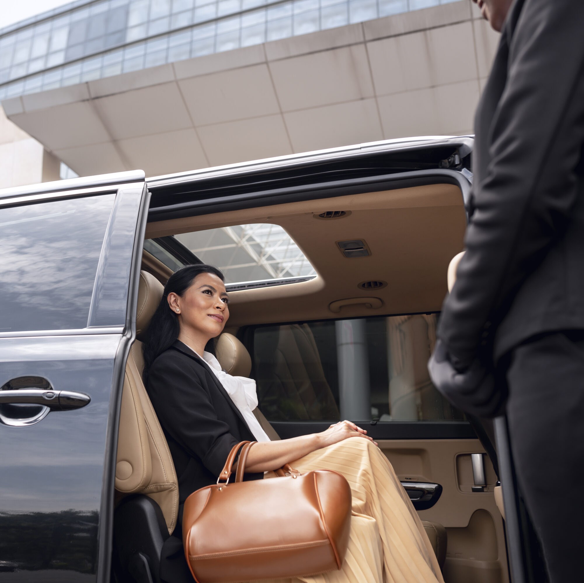 Interior kendaraan premium yang nyaman dengan pemandangan dari jendela, menjamin privasi selama perjalanan.