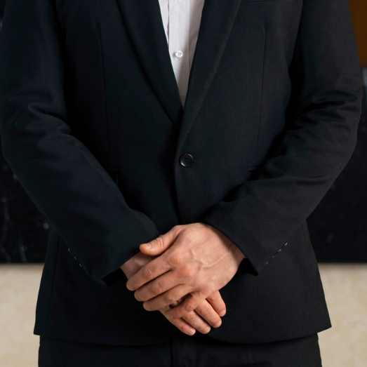 Pria profesional berjas hitam merepresentasikan layanan luxury concierge dan asisten perjalanan pribadi