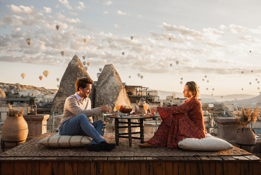 sunrise breakfast teras rooftop berlatar belakang ratusan balon udara cappadocia di private trip turki triplelines
