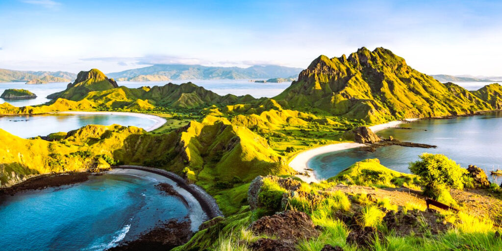 Panoramic aerial view of Padar Island featuring rugged green hills and turquoise bays in Labuan Bajo, Komodo National Park