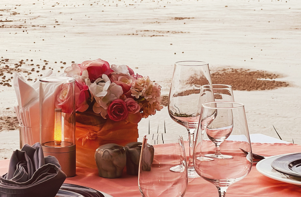 private beach dinner set up shaded daybeds cocktails pantai merah