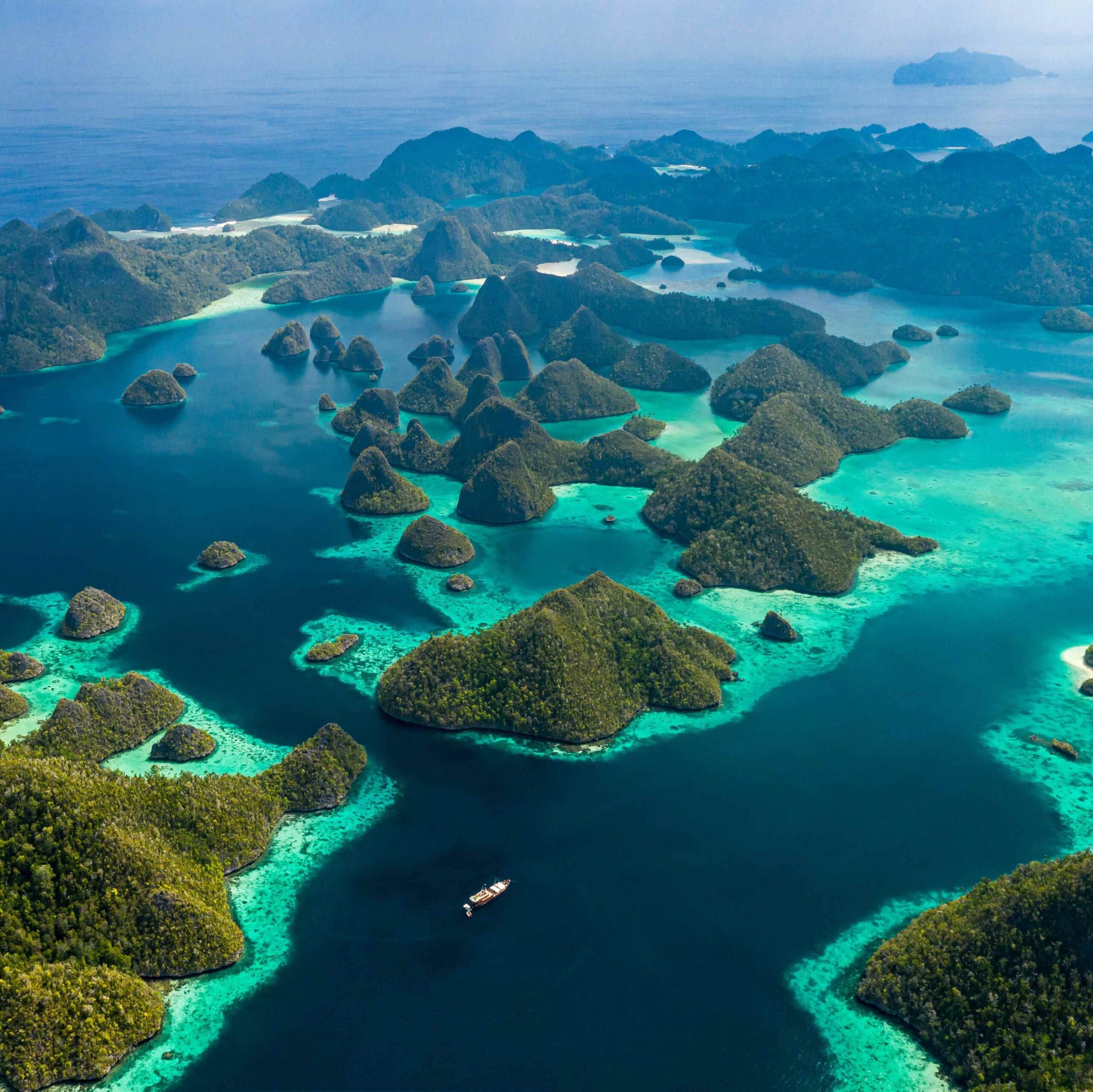 Gugusan pulau hijau di tengah laut biru, destinasi impian untuk petualangan kurasi Triplelines raja ampat.