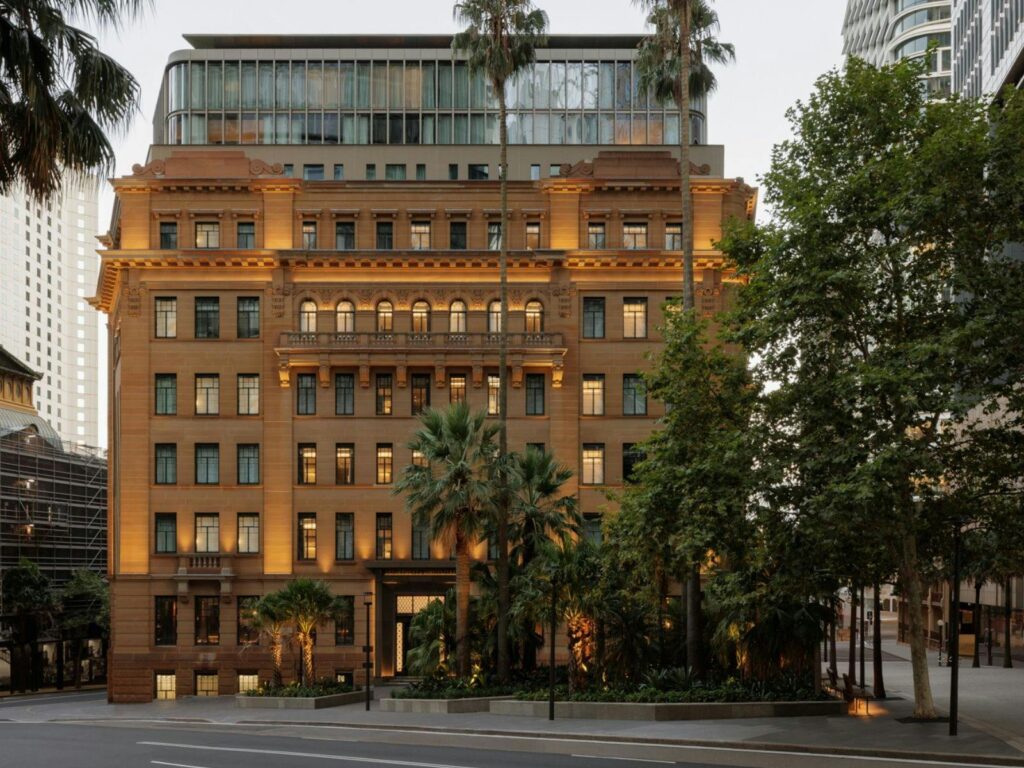 Fasad megah Capella Hotel dengan arsitektur klasik yang menawan di malam hari, pilihan akomodasi dalam layanan triplelines private trip luxury Australia.