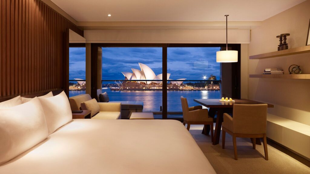 Kamar hotel mewah di Park Hyatt Sydney dengan pemandangan langsung ke Sydney Opera House di malam hari, salah satu akomodasi terbaik dari triplelines private trip luxury Australia.