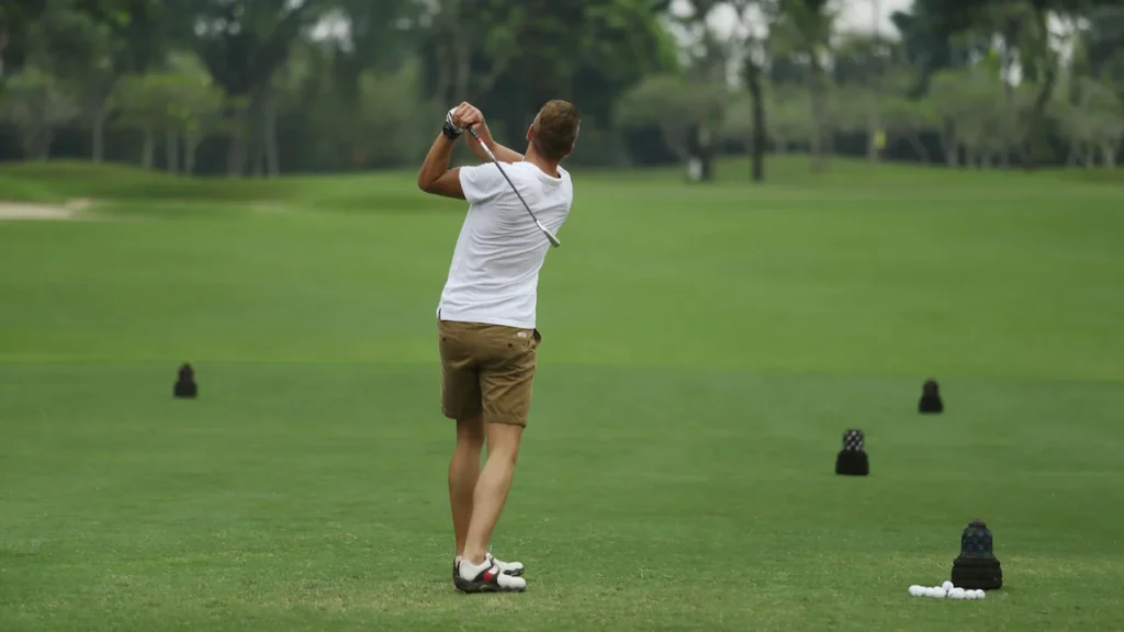 A man enjoys a round of golf on the lush, tropical green course at Hyatt Regency Yogyakarta, capturing the active side of the Echoes of Java Journey.